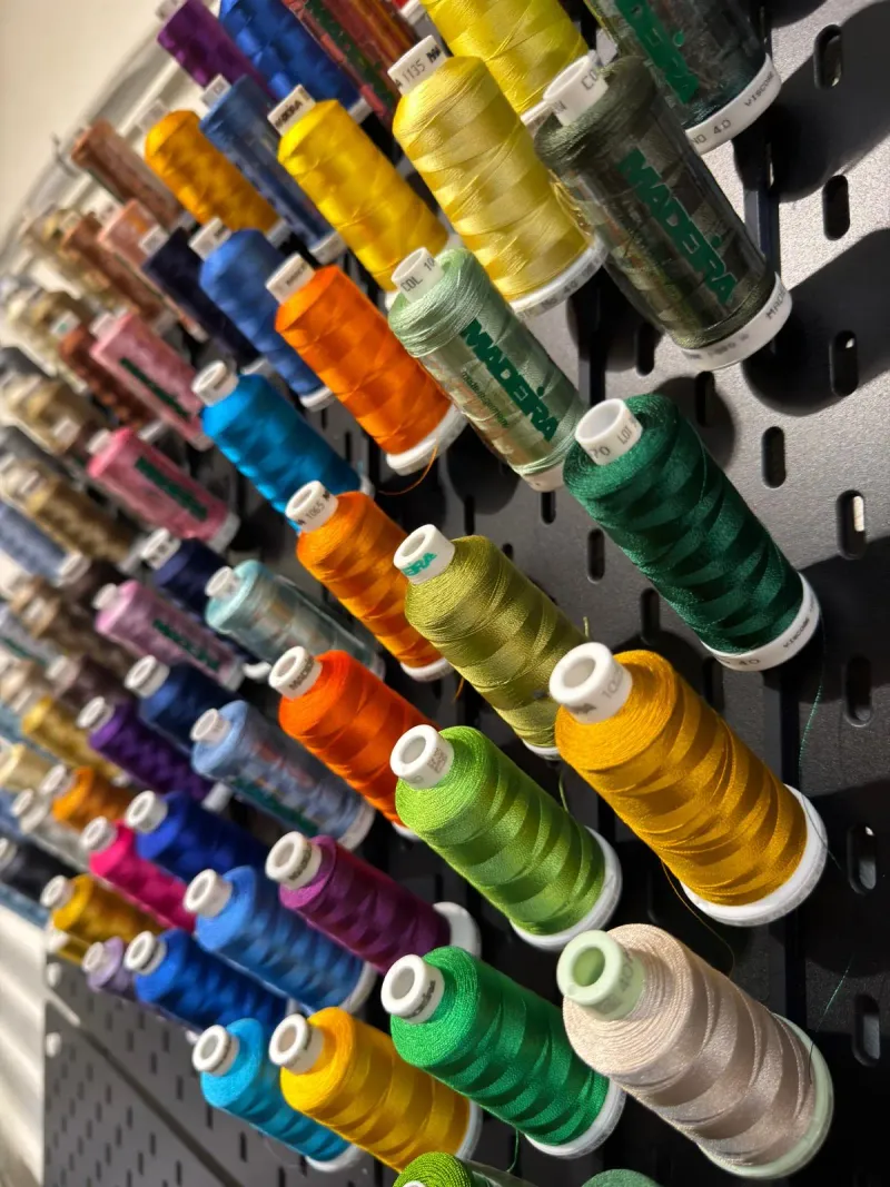 Wand vol borduurgaren in verschillende kleuren